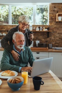 Cute mature couple using laptop
