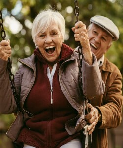 Man pushing partner on swing