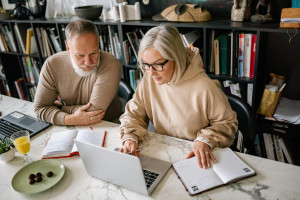 middle age couple looking at laptop in an office