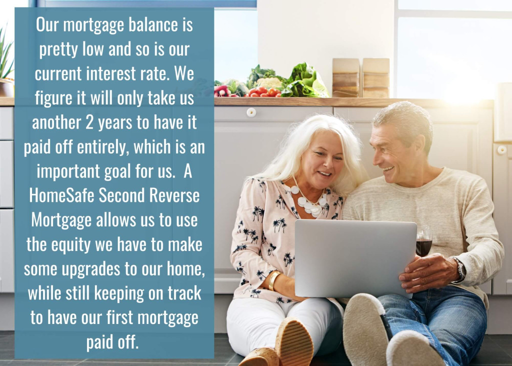 senior couple sitting on floor of kitchen looking a laptop